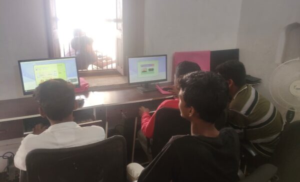 Facilitator supporting children to learn computer skills